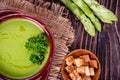 Fresh asparagus creamy soup and ingredients on a wooden table. Royalty Free Stock Photo