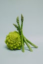Fresh Asparagus and Romanesque cabbage on a grey background