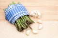 Fresh asparagus stems in a textile napkin and garlic Royalty Free Stock Photo