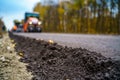 Fresh asphalt on highway construction site. Industrial pavement machine laying.