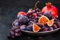 Fresh autumn fruits -  figs, plums, grapes and pomegranate on dark Royalty Free Stock Photo