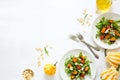Fresh autumn salad with baked pumpkin, arugula, cheese and seeds on white table cloth