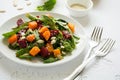 Fresh autumn salad with marinated pumpkin and beetroot, spinach leaves,olive oil, sesame and pumpkin seeds