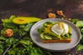 Fresh avocado breakfast with egg poached sandwich. Green salad a
