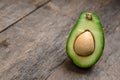 Fresh Avocado cut in half on wooden board with knife background Royalty Free Stock Photo