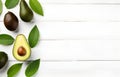 fresh avocado fruit with leaves on white wooden table for healthy life eating and diet card design