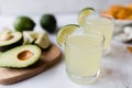 Fresh avocado, lime, drink and nacho chips lying on marble background. Recipe for Cinco de Mayo party Royalty Free Stock Photo