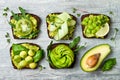 Fresh avocado toasts with different toppings. Healthy vegetarian breakfast with rye wholegrain sandwiches. Royalty Free Stock Photo