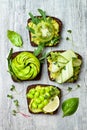 Fresh avocado toasts with different toppings. Healthy vegetarian breakfast with rye wholegrain sandwiches. Royalty Free Stock Photo