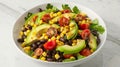 Fresh Avocado, Tomato, Corn, and Black Bean Salad Bowl on Marble Background Royalty Free Stock Photo