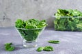 Fresh baby spinach leaves in a glass bowl and behind on a texture table. Detox vitamin diet Royalty Free Stock Photo