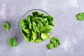 Fresh baby spinach leaves in a glass bowl on a textured gray background. Top view Royalty Free Stock Photo
