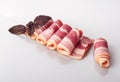 Bacon in slices and rolls with a sprig of fresh red Basil isolated on a white background Royalty Free Stock Photo