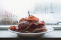 Fresh bake ham in white dish with raindrop on window in the morning