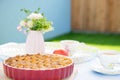 Fresh baked apple pie, cup of tea and flowers on a table Royalty Free Stock Photo