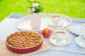 Fresh baked apple pie, cup of tea and flowers on a table Royalty Free Stock Photo