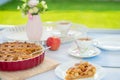 Fresh baked apple pie, cup of tea and flowers on a table Royalty Free Stock Photo