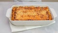Fresh baked beef lasagna in baking dish close up on kitchen table Royalty Free Stock Photo