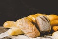Fresh baked bread with a golden crust, loaf, buns, white, rye on a rustic wooden background . Horizontal frame Royalty Free Stock Photo