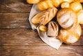 Fresh baked bread with a golden crust, loaf, buns, white, rye on a rustic wooden background with sil rustic. Flat layout