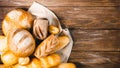 Fresh baked bread with a golden crust, loaf, buns, white, rye on a rustic wooden background with sil rustic. Flat layout