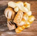 Fresh baked bread with a golden crust, loaf, buns, white, rye on a rustic wooden background with sil rustic. Flat layout