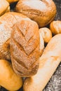 Fresh baked bread with a golden crust, loaf, buns, white, rye on a rustic wooden background with sil rustic. Flat layout