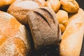 Fresh baked bread with a golden crust, loaf, buns, white, rye on a rustic wooden background with sil rustic. Flat layout