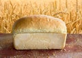 Fresh baked bread on wooden table on background field wheat Royalty Free Stock Photo