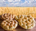 Fresh baked bread on wooden table on background field wheat Royalty Free Stock Photo