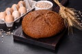 Fresh baked brown bread with ears and grains of wheat Royalty Free Stock Photo