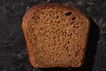 Fresh baked brown bread slice on stone black surface Royalty Free Stock Photo