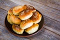 Fresh baked buns sprinkled with sesame seeds in a plate on a wooden table Royalty Free Stock Photo