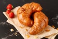 Fresh baked butter breakfast croissants and crumbs  and strawberries on paper Royalty Free Stock Photo