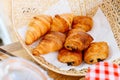 Fresh baked Classic Butter Croissants and Raisin Croissant inside weaving basket