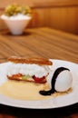 Fresh baked Eclair pastry with cream, strawberry, ice cream sorbet and vanilla sauce Royalty Free Stock Photo