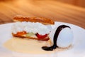 Fresh baked Eclair pastry with cream, strawberry, ice cream sorbet and vanilla sauce Royalty Free Stock Photo