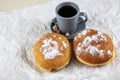 Fresh baked and garnished with powdered sugar german doughnuts - Berliner or Krapfen - on white table