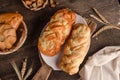 Fresh baked goods - delicious wicker buns on wooden background