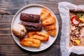 Fresh baked goods on white dish including scone, croissant, financier and chocolate financier