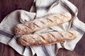 Fresh baked homemade crusty french baguette. Two loaves on linen towel