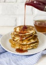 Homemade pancake poured syrup drops in white plate, closeup