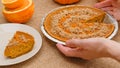 Fresh baked homemade pumpkin pie decorated with crushed nuts and orange zest. Woman hands serving pie on a plate Royalty Free Stock Photo