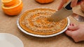 Fresh baked homemade pumpkin pie decorated with crushed nuts and orange zest. Woman hands serving pie on a plate Royalty Free Stock Photo