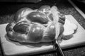 Loaf of challah bread being cut with knife. Royalty Free Stock Photo