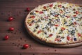The fresh baked pizza with olives and tomatoes on the wooden background Royalty Free Stock Photo