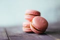 Fresh baked purple pink macaroon pastry cookies macarons, macaroni in retail store display, close up, low angle view