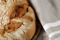 A fresh  baked rye wheat loaf of bread  closeup on a wooden board with linen towel Royalty Free Stock Photo