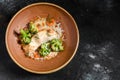 Fresh baked sea fish with broccoli, carrots, vegetables and cheese