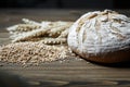 Fresh baked wheat bread loaf, a handful of wheat grain and wheat ears on a dark brown wooden background Royalty Free Stock Photo